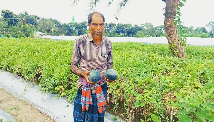 নগরঘাটা এলাকার এক কৃষক ব্ল্যাক বেবি তরমুজ হাতে নিয়ে উচ্ছ্বাস করছেন। ছবি- লাল সবুজের কথা।
